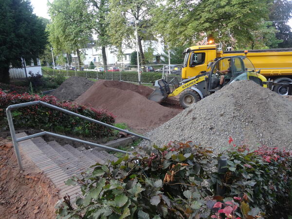 Foto der Baumaßnahmen im Park Ville d'Eu. Es sind die Erdarbeiten und zwei Baustellenfahrzeuge zu sehen.